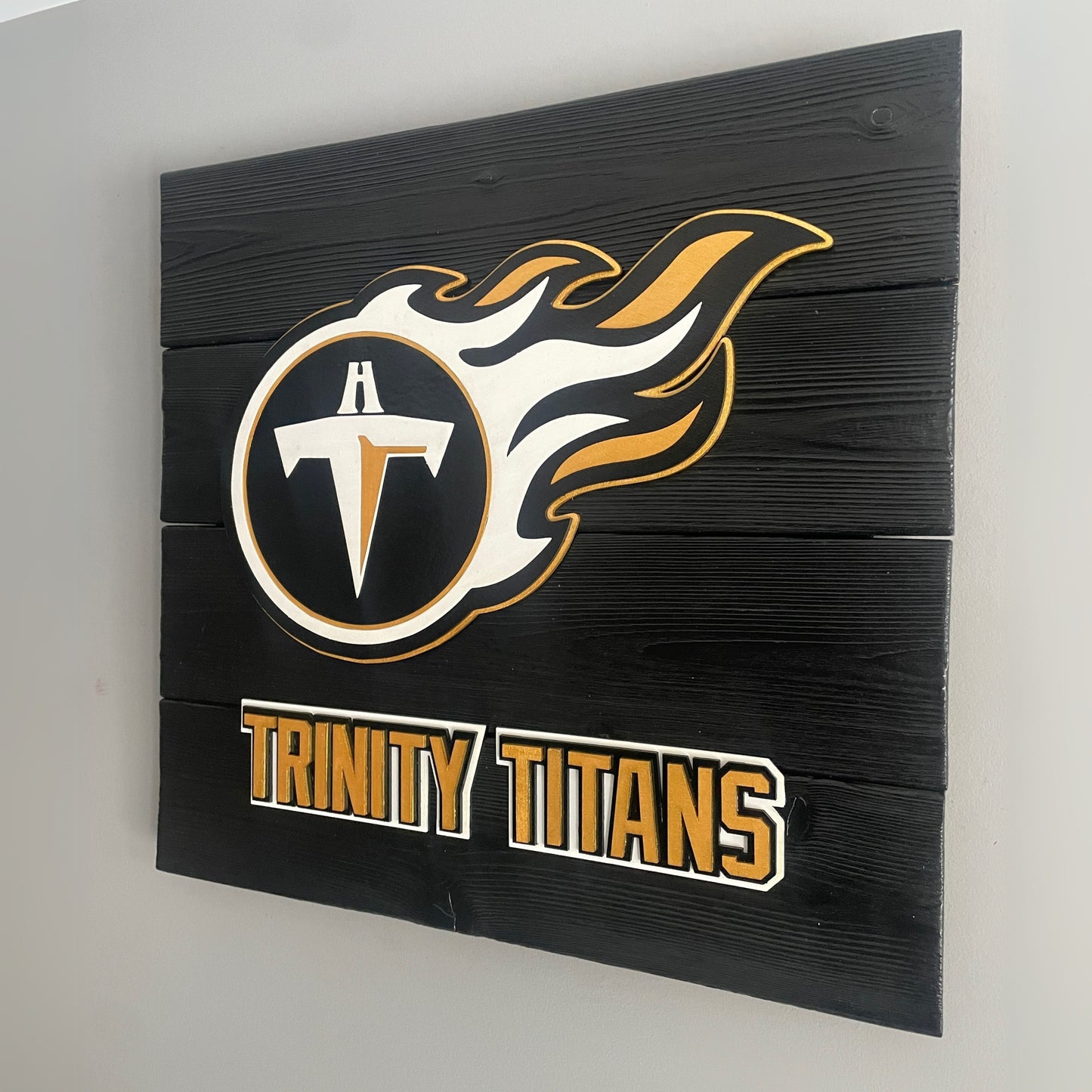 Custom Trinity Titans Shou Sugi Ban sign featuring the school's logo and name on black boards. The handcrafted wooden sign showcases a bold, charred wood finish for a striking and durable design, perfect for displaying school pride.